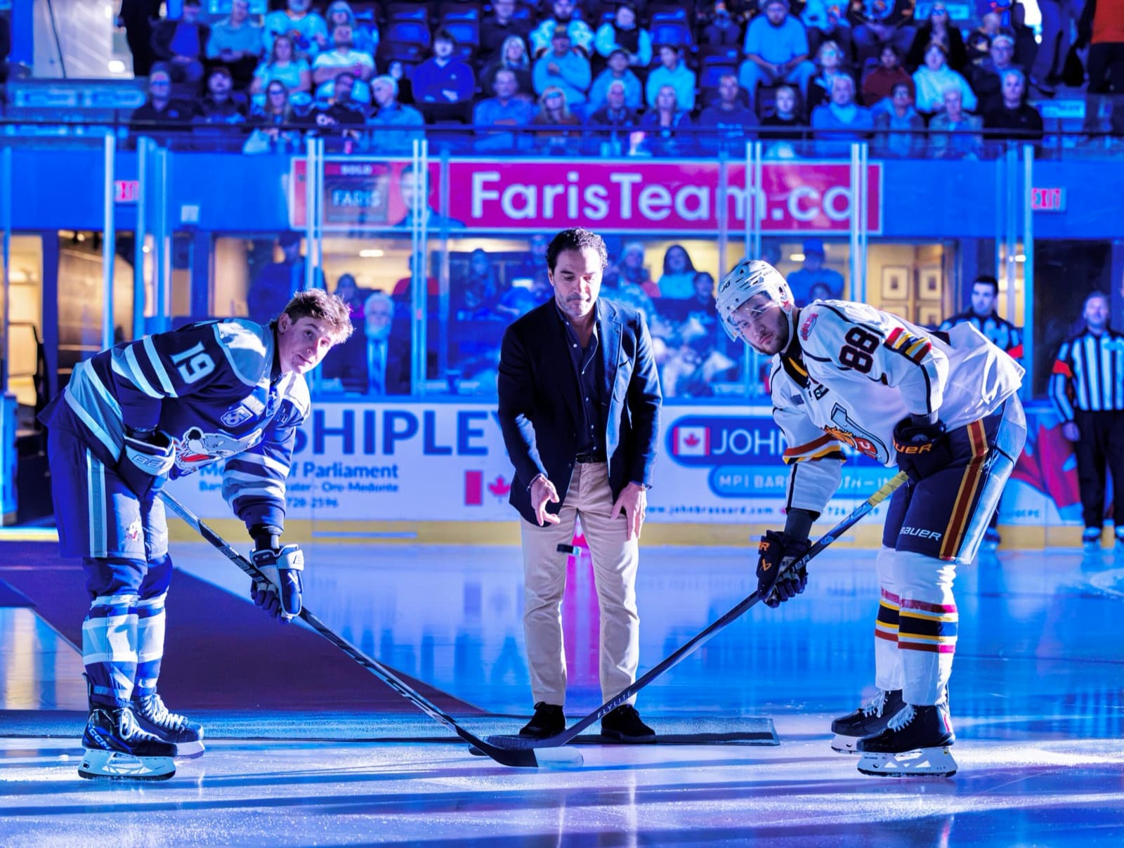 John Careri drops the ceremonial puck between two players at centre ice before the Barrie Colts' home opener